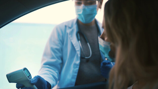 Doctor, face mask and car with screening results for temperature, fever or safety in city. Woman, healthcare worker or medical exam with infrared scanner for viral assessment or outbreak regulations