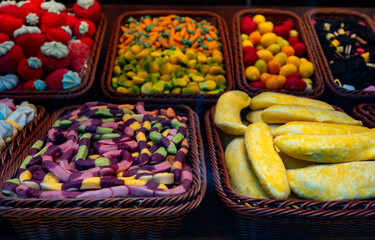 Assortment of colorful gummy candies in baskets.