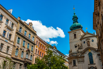 Obraz premium Ancient Saint Gall Church tower among Prague city buildings.