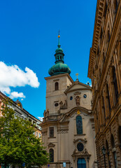 Fototapeta premium Ancient Saint Gall Church tower among Prague city buildings.