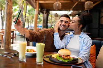 Happy couple shares a moment and a tasty meal at a charming outdoor eatery during their getaway