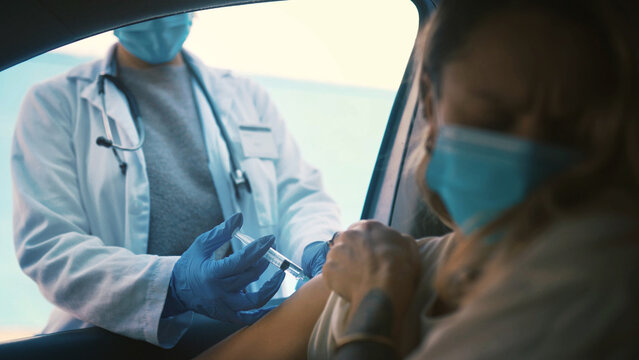 Car, healthcare or vaccine with doctor and patient in drive through for cure, injection or shot. Border, needle or syringe with driver person and medical professional at vehicle for treatment