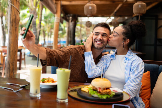 Happy couple shares a moment and a tasty meal at a charming outdoor eatery during their getaway