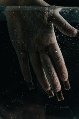 Burned Hands Submerged in Water with Rising Bubbles