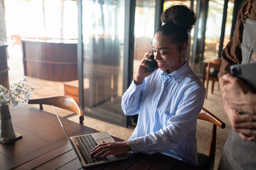 Woman entrepreneur managing her business from remote work. Working on laptop in restaurant