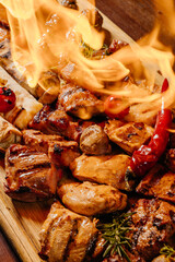 Charred assortment of meats and vegetables engulfed in vivid flames, capturing dramatic heat, destruction, and raw texture as an artistic visual metaphor of fire’s aftermath.