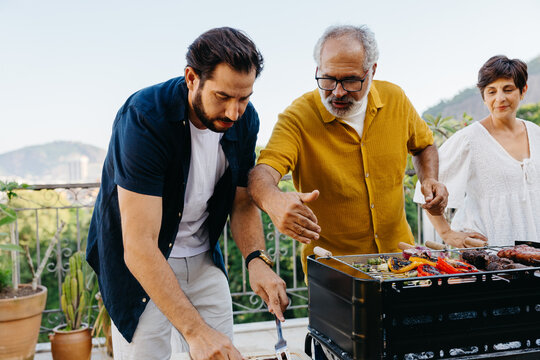 Family enjoying a traditional Brazilian churrasco outdoor barbecue together