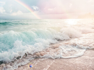 Calm ocean wave beach rainbow pastel sunrise soft light foam shore serene mood relaxation seascape coastal nature horizon mist spray