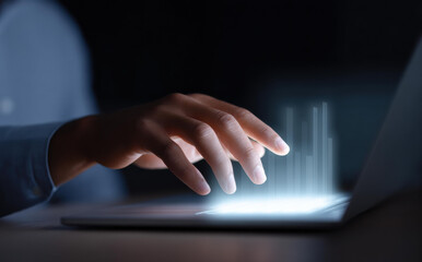 Focused hand touching futuristic laptop with blue light technology. person interacts with virtual screen in dark, symbolizing digital innovation, cyber connection, and network