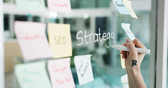 Branding, hands and writing on glass wall for business growth, seo plan and target audience trends. Marketing, increase awareness and person at board with sticky note, strategy and goals for campaign