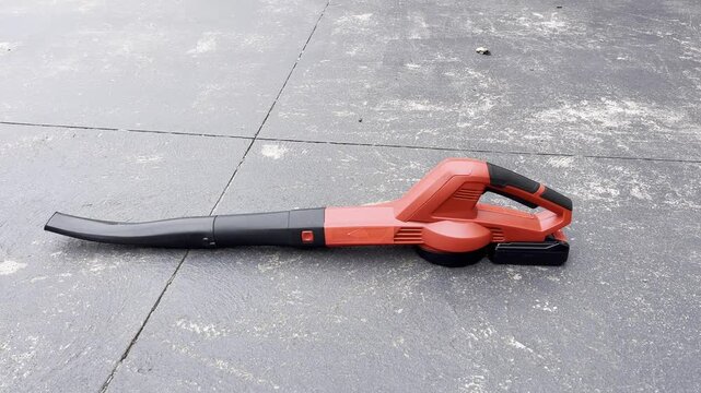 Red leaf blower on pavement