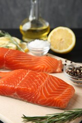 Pieces of salmon fillet, spices, lemon and oil on table, closeup