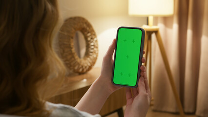 Woman use digital tech cell phone green screen mock up talk video call. Hand swipe click phone web site middle center. Girl hold mobile. Chroma key page. Cozy home background. Online app copy space.