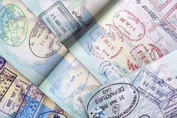 Many open passport pages with lots of visas and entrance stamps from various countries passport...