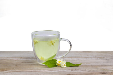 Fresh herbal tea with jasmine. glass cup on wooden table