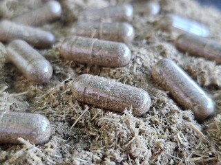 Herbal supplements scattered on a bed of natural plant concept