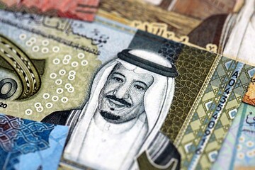 Saudi Arabia riyal money bills banknotes lies in big pile on table close up. Concept of finances...