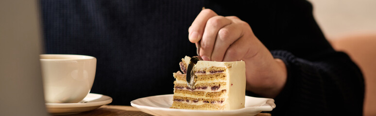 Mature man enjoying a delicious slice of cake in a cozy cafe during a sunny afternoon