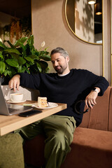 Mature man enjoying coffee and cake in a stylish cafe setting