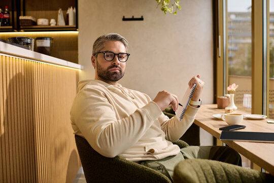 Stylish mature man enjoying a quiet moment of reflection in a cozy cafe setting
