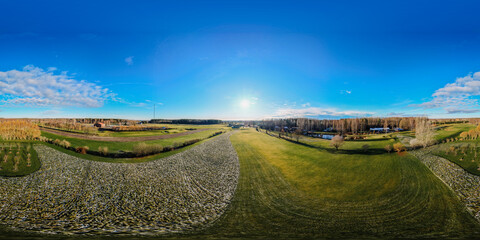 Expansive green landscape under a bright blue sky with fluffy clouds, showcasing rolling hills, trees, and a serene atmosphere, perfect for nature enthusiasts and outdoor lovers