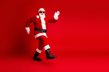 Santa in red studio outfit dancing joyful holiday scene for Christmas themed stock photo