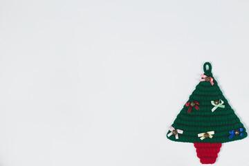 Handmade crochet christmas tree ornament with festive decorations and red base