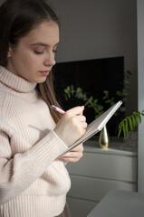 Young woman writing notes in notebook