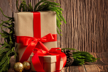 Festive christmas presents wrapped in kraft paper with red ribbons and greenery