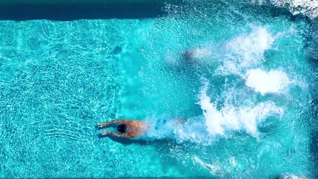 Overhead view of a happy family jumping together in the swimming pool as a summer holidays travel concept with copy space