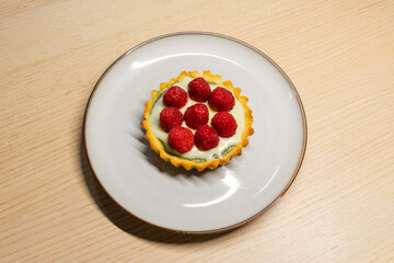 A plate of matcha white chocolate raspberry tart.