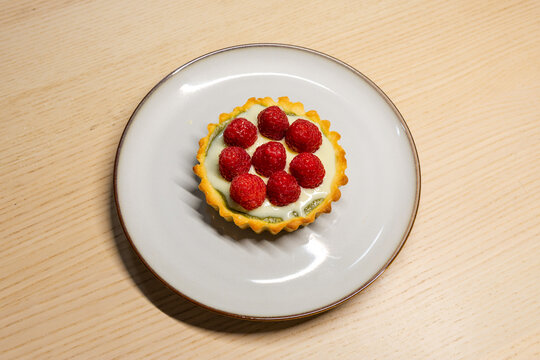 A plate of matcha white chocolate raspberry tart.