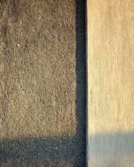 Fototapeta premium Sunlit rough and smooth wall textures with vertical contrast soft tone