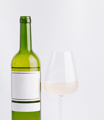 Elegant green wine bottle beside a clear glass of white wine