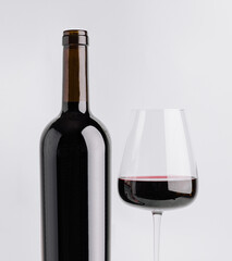 Elegant red wine bottle and glass on white background for wine lovers