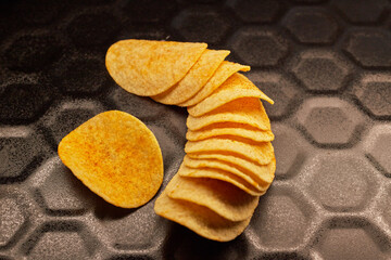 Close-up of several potato chips on a black baking tray