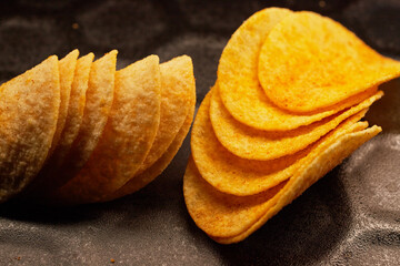 Close-up of several potato chips on a black baking tray