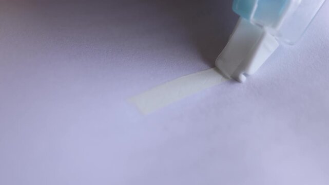 Correction tape covering blue pen marks on paper, representing editing, fixing mistakes, and document accuracy