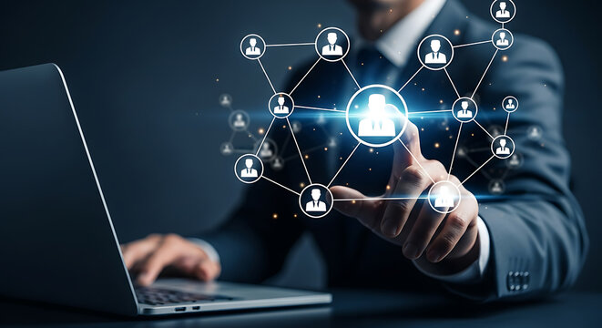 Businessman pointing at a network of people icons connected by lines while using a laptop, representing social media, human resources, and business connections.