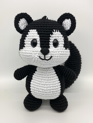 A Cute handcrafted skunk amigurumi with adorable details. The skunk features a unique crochet texture and a smiling expression