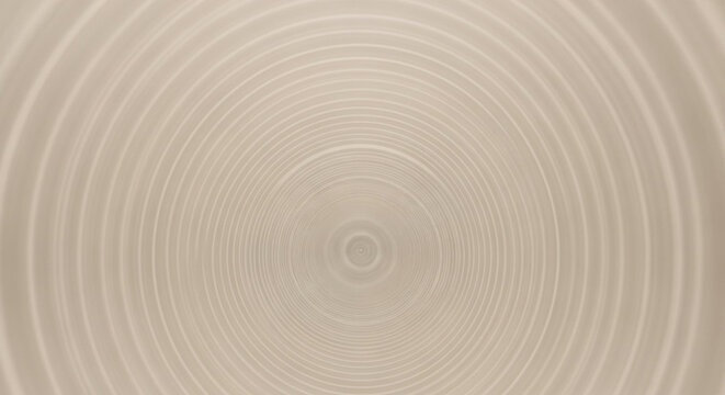 Abstract concentric circles radiating from a central point on a beige background