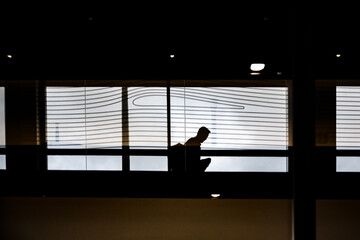 Silhouette of tourists in the glass building of the airport, railway station. tourists with backpacks, bags. Travel concept . People journey on holidays.