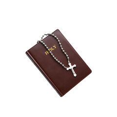 A silver rosary rests upon a dark red bible symbols of faith