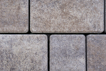 textured grey rectangular concrete paving stones close up view, uniform outdoor sidewalk pattern, concept of construction, building material, landscaping