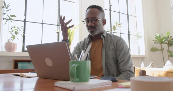 Mid Adult Male Working form Home on Videocall using Laptop Technology