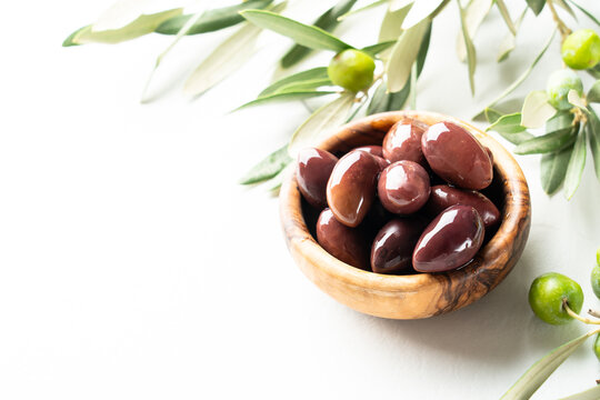 Olives in the bowl at white table. - Powered by Adobe