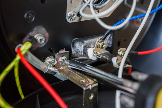 Process of fixing broken multicooker with screwdriver, closeup photo. Close-up of internal wiring in disassembled multicooker