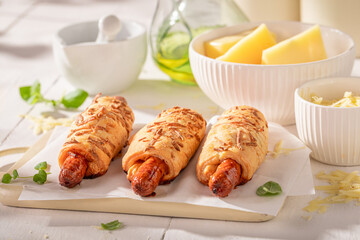 Unhealthy hot dogs with herbs and cheddar cheese.