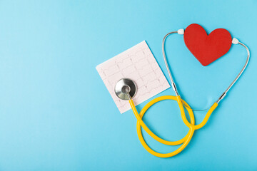Medical stethoscope, red heart, and cardiogram on a color background. ECG, Heart wave, heart attack, cardiogram report. Cardiogram pulse trace and heart concept. Healthcare.Space for text