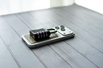 Smartphone and credit card with a combination padlock on top, symbolizing data protection, digital security